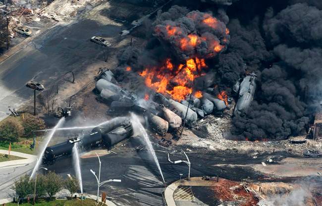 Smoke rises from flaming railway cars that were carrying crude oil after it a train derailed in downtown Lac Megantic, Quebec.