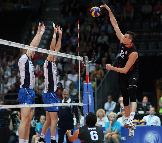 Gavin Schmitt of Canada attacks against a block from Finland's Jukka Lehtonen and Mikko Oivanen during volleyball action at the Hakametsa Ice Hockey Arena in Tampere, Finland in this undated handout photo.
