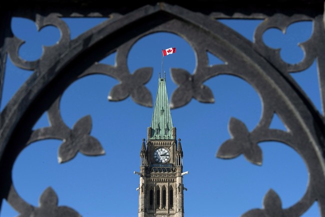 Centre Block's Peace Tower is shown through the gates of Parliament Hill, Feb. 11, 2014.