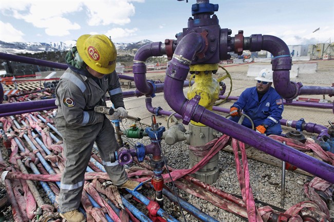 Workers tend to a well head at an Encana fracking gas well outside Rifle, in western Colorado March 29, 2013.