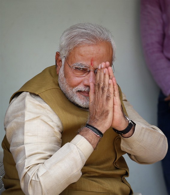 Opposition leader and India's next prime minister Narendra Modi greets supporters during a visit to seek his mother's blessings after preliminary results showed his party winning by a landslide, in Gandhinagar, in the western Indian state of Gujarat, Friday, May 16, 2014.