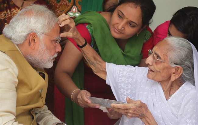 90-year-old Hiraben marks the forehead of her son and India’s next prime minister Narendra Modi with vermillion as a sign of blessing in Gandhinagar, in the western Indian state of Gujarat, Friday, May 16, 2014.
