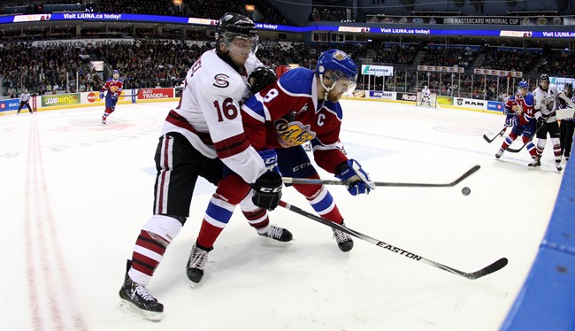 Guelph Storm's Kerby Rychel battles for the puck with Edmonton Oil Kings' Griffin Reinhart during second period Memorial Cup action in London, Ontario, Saturday, May 17, 2014. 