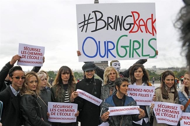 French actresses and models pose in front of the Eiffel Tower holding placards saying: Bring back our girls, during a rally at the Trocadero, to show support for the release of the kidnapped girls in Nigeria in Paris, Tuesday May 13, 2014. 
