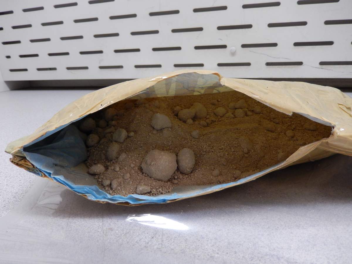 Seized suspected heroin and false bottom suitcase used to conceal the narcotics.