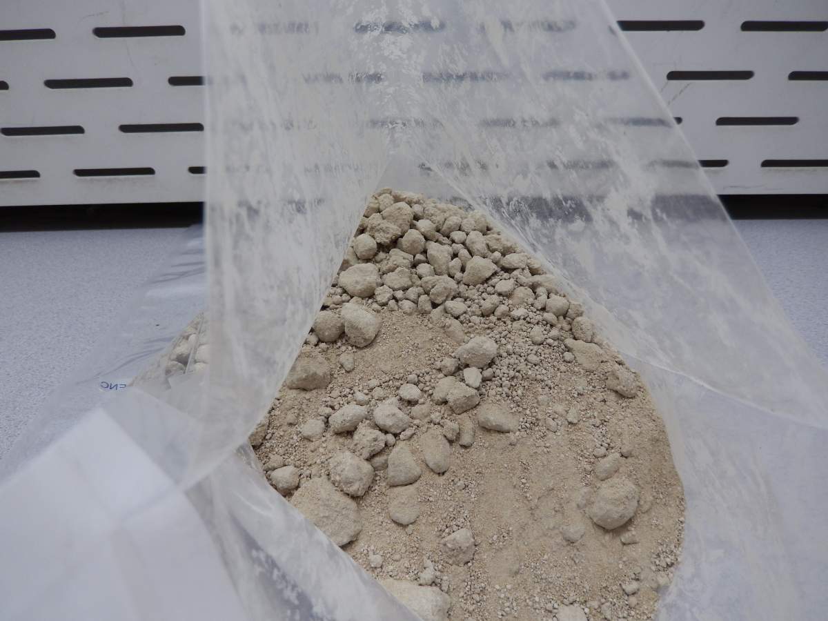 Seized suspected heroin and false bottom suitcase used to conceal the narcotics.