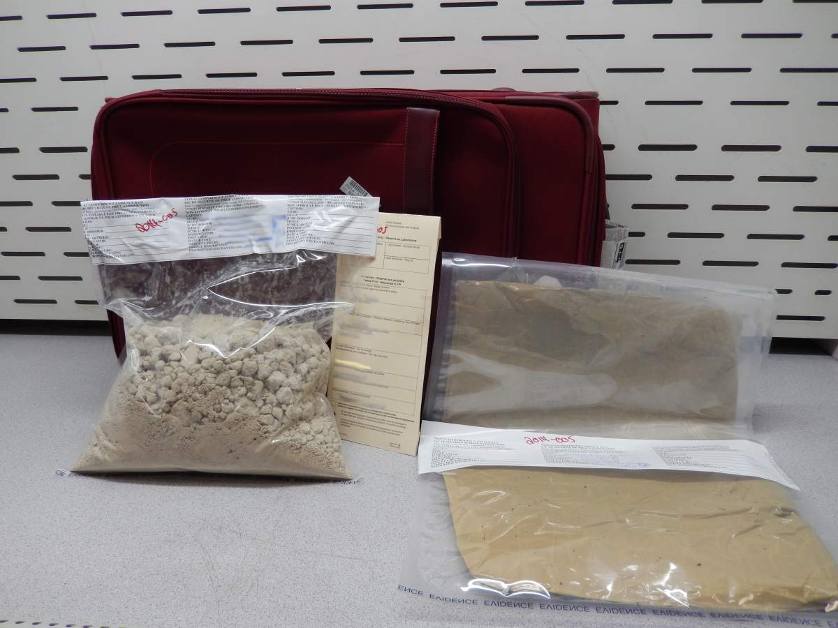 Seized suspected heroin and false bottom suitcase used to conceal the narcotics.