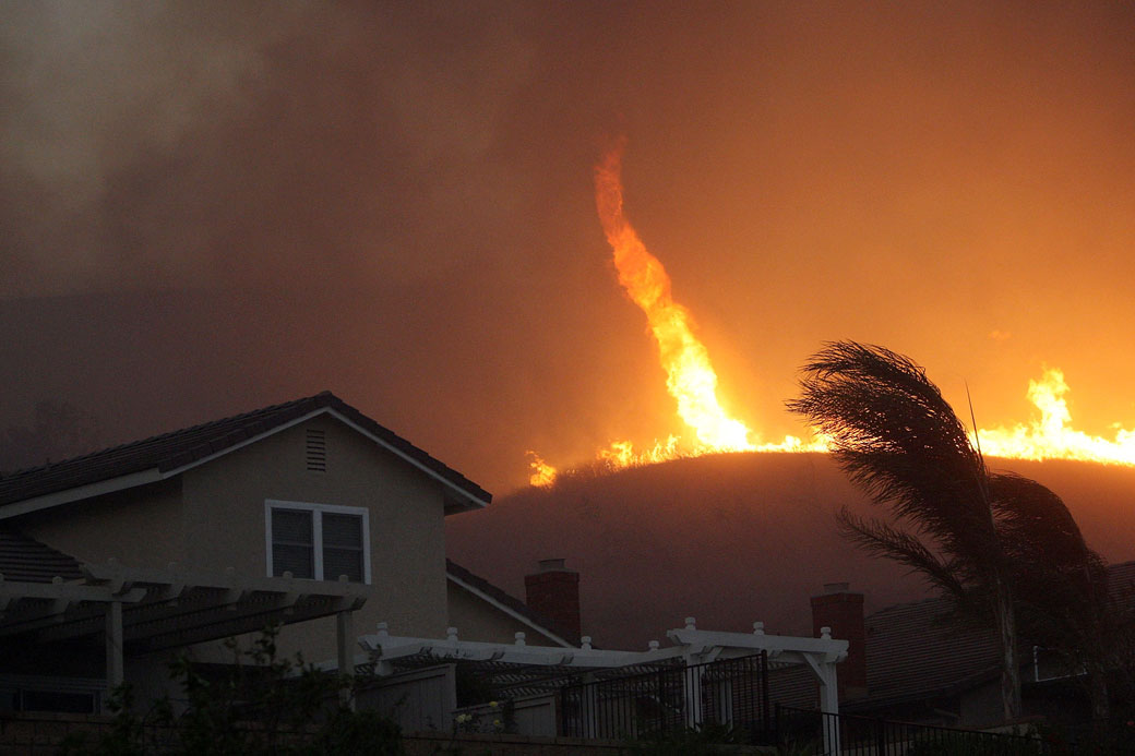 A fire tornado comes close to homes during the Corona Fire on November 2008.