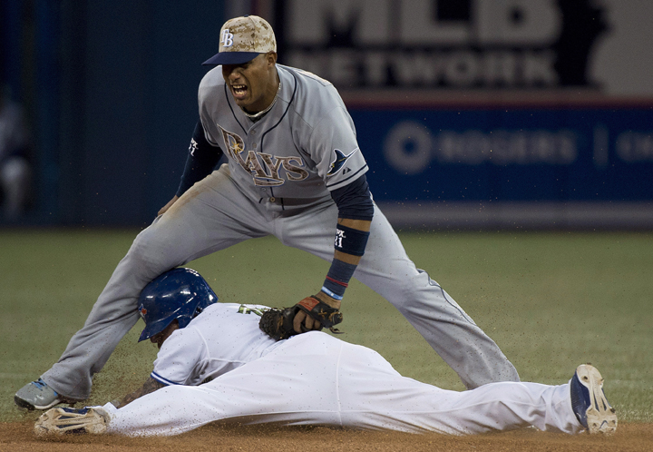 Toronto Blue Jays Brett Lawrie, bottom, slides safe into second base past Tampa Bay Rays shortstop Yunel Escobar, top, after Lawrie hit a double during fifth inning AL baseball action in Toronto on Monday, May 26, 2014. 