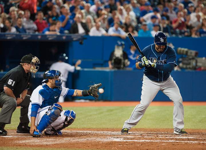 Toronto Blue catcher Dioner Navarro continues to catch after his hand was hit with a bat during by Tampa Bay Ray Jose Molina, right, during third inning MLB action in Toronto on Tuesday May 27, 2014. 