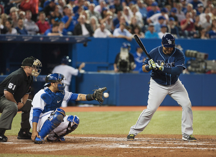 Toronto Blue catcher Dioner Navarro continues to catch after his hand was hit with a bat during by Tampa Bay Ray Jose Molina, right, during third inning MLB action in Toronto on Tuesday May 27, 2014. 