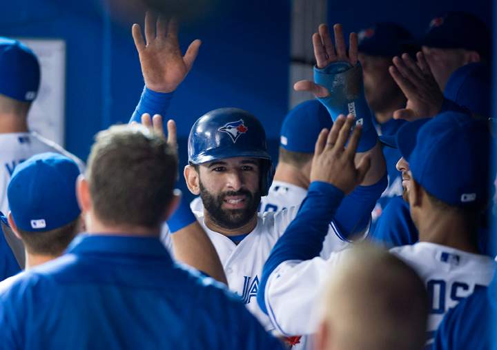 Toronto Blue Jays' Jose Bautista celebrates in the dugout after scoring on an Edwin Encarnacion two-run single in the first inning of MLB baseball action against the Tampa Bay Rays in Toronto on Wednesday, May 28, 2014. 