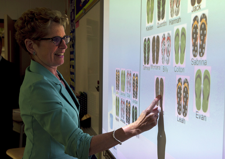 Ontario Liberal leader Kathleen Wynne checks student attendance on a smart board during a visit to Holy Cross school in Sault Ste. Maire, Ontario during a capaign stop on Tuesday May 20, 2014, 2014.