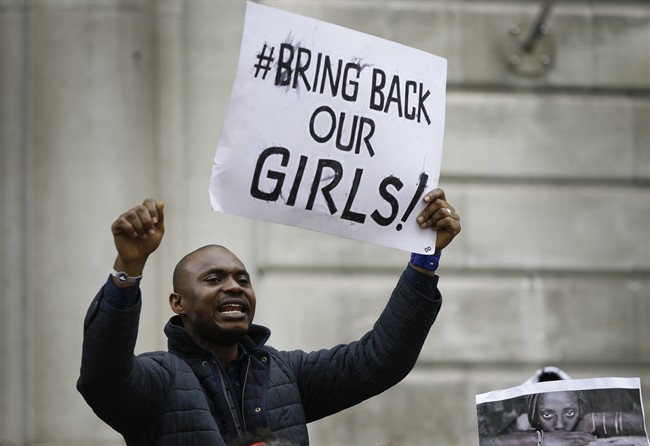 A demonstrator holds a banner, during a protest about the kidnapping of girls in Nigeria, near the Nigerian High Commission in London, Friday, May 9, 2014.