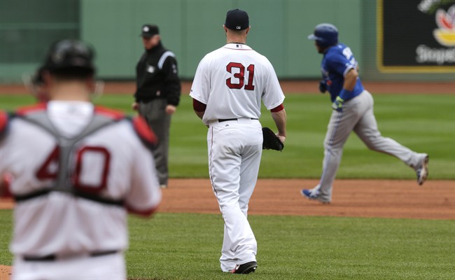Boston Red Sox starting pitcher Jon Lester (31) watches Toronto Blue Jays' Melky Cabrera, right, round the bases on a solo home run during the first inning of a baseball game at Fenway Park, Thursday, May 22, 2014, in Boston. (AP Photo/Charles Krupa).