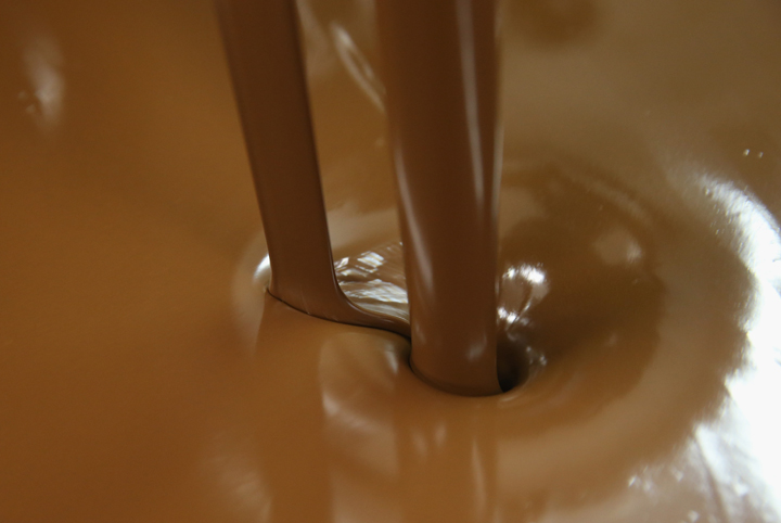 Milk chocolate flows into a vat at the production facility at Confiserie Felicitas chocolates maker on April 9, 2014 in Hornow, Germany. 