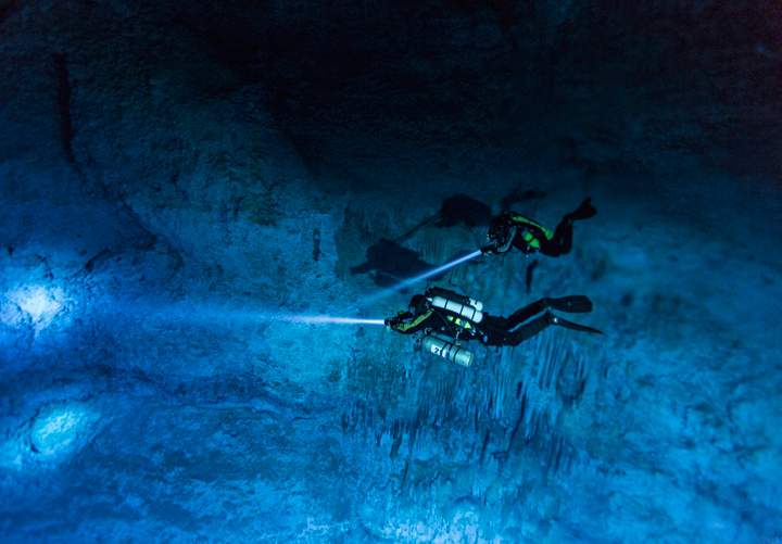 In this June 2013 photo provided by National Geographic, divers make their way toward Hoyo Negro, an underwater cave in Mexico’s Yucatan Peninsula where the remains of “Naia,” a teenage girl who lived 12,000 to 13,000 years earlier, were found.