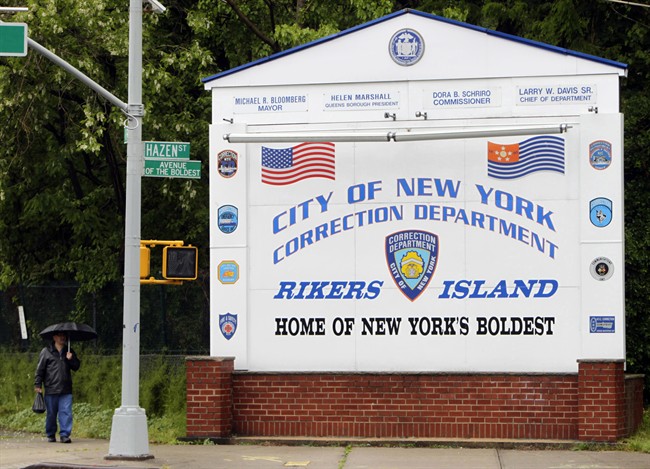  In this May 17, 2011, file photo, a man walks near the sign at the entrance to the Rikers Island jail in New York.