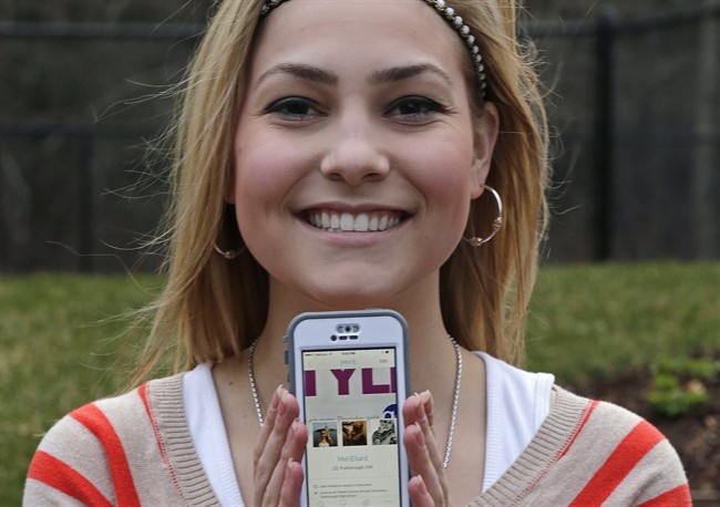 Melissa Ellard poses showing her Hinge profile on her iPhone, in Foxborough, Mass. Ellard says she wouldn’t have gone on a date in the past six months were it not for Hinge, a dating app whose promise hinges on its ability to hook you up with friends of friends.