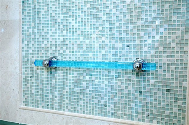 This photo provided by Best Bath Systems shows a Great Grabz Horizon aquarium acrylic grab bar with satin chrome fixtures in a bathroom. A 2012 survey found about half of those ages 55 to 64 thought that bathroom aids, such as grab bars and shower seating, were “essential” or “desirable.” That rose to nearly two-thirds among those age 65 and older.