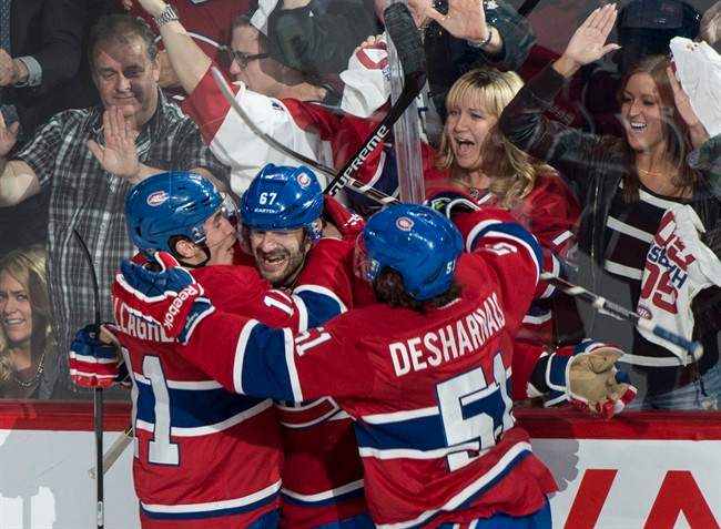 Montreal Canadiens' Max Pacioretty, centre, celebrates his goall against the Boston Bruins with teammates Brendan Gallagher, left, and David Desharnais during second period NHL playoff hockey action on Monday, May 12, 2014 in Montreal. 