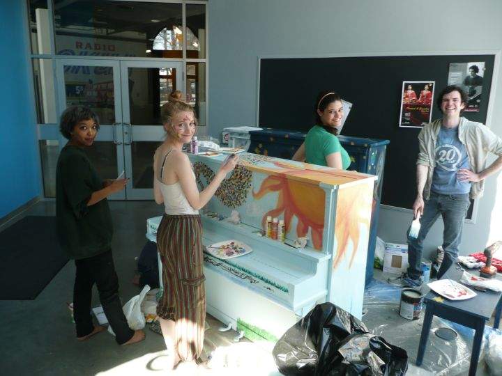 David Rauch, R, paints upright pianos, along with student volunteers.