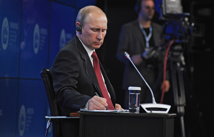 Russian President Vladimir Putin makes notes during the St.Petersburg International Investment Forum in St Petersburg, Russia, Friday, May 23, 2014. 