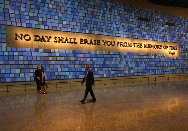 A woman places a hand on the names engraved along the South reflecting pool at the Ground Zero memorial site during the dedication ceremony of the National September 11 Memorial Museum in New York May 15, 2014 in New York City.