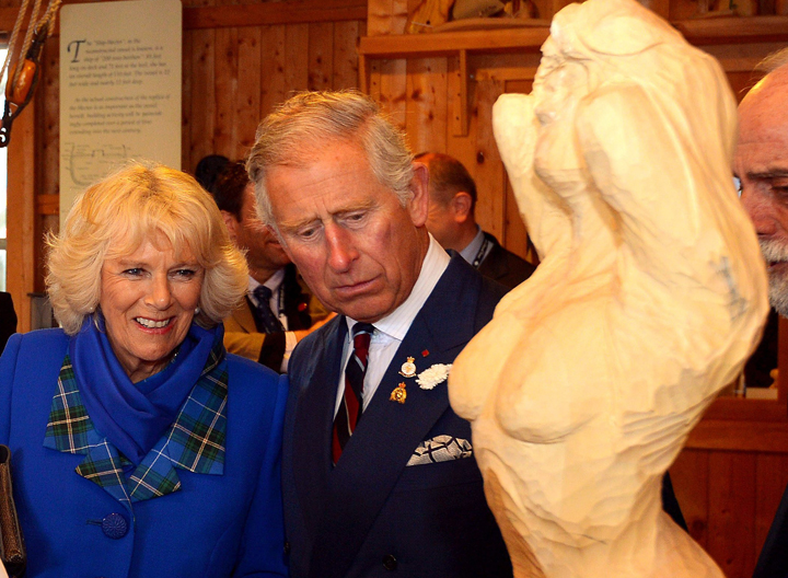 The Prince of Wales and the Duchess of Cornwall study a wood carving of a ship's figure head, during a visit to the Hector Quay Museum in Pictou county, Nova Scotia, at the start of their Royal trip to Canada.