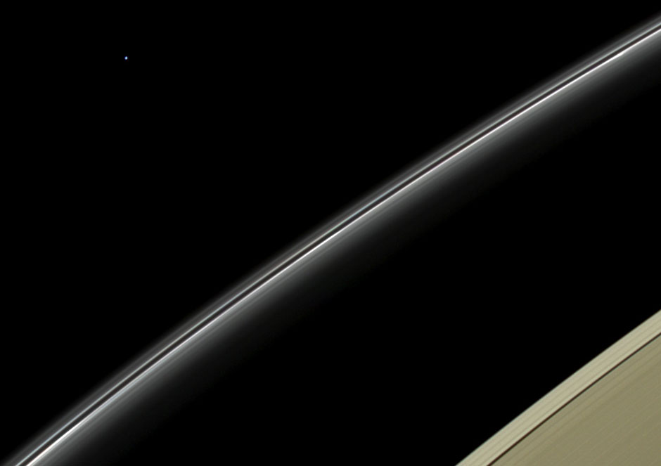 Uranus, the pale, blue dot at upper left, hangs above Saturn's rings.
