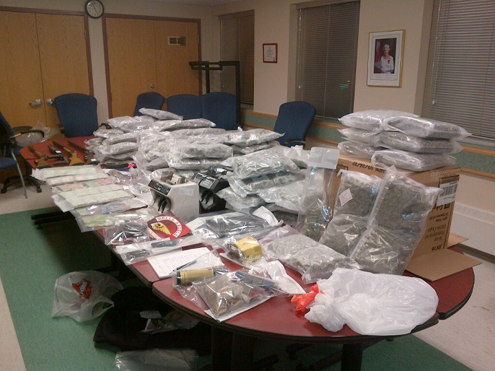 The Mounties showed pictures of a boardroom table covered in 71.2 kilograms of packaged marijuana, almost a kilogram of cocaine and four guns seized from a home on Murdoch Drive in the RM of St. Clements just after midnight Saturday.