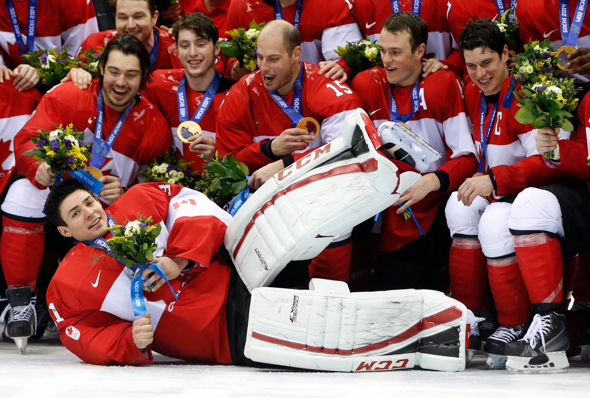 Canada goalie Carey Price, front, lies on the ice as he poses with teammates after Canada beat Sweden 3-0 in the men's ice hockey gold medal game at the 2014 Winter Olympics, Sunday, Feb. 23, 2014, in Sochi, Russia.