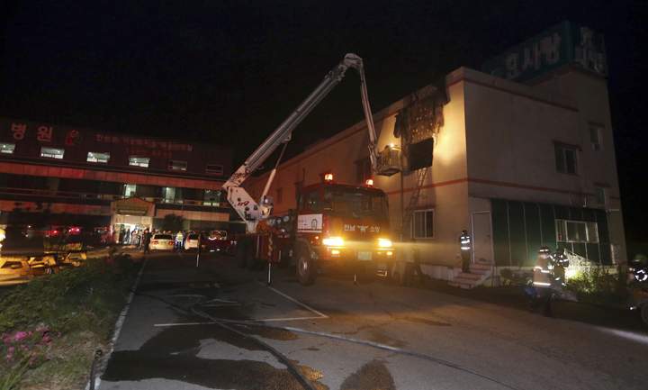 Firefighters work after a fire at a hospital annex housing elderly patients in Jangseong, South Korea, Wednesday, May 28, 2014. 