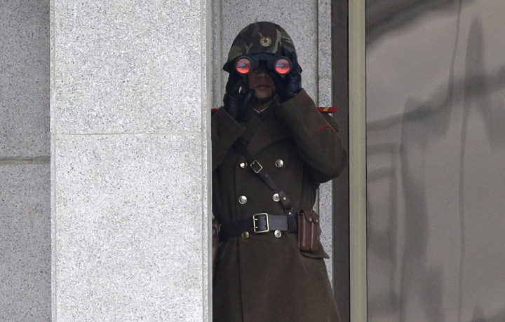 A North Korean soldier looks at the south side through a pair of binoculars at the border village of Panmunjom, which has separated the two Koreas since the Korean War, in Paju, north of Seoul, South Korea, Wednesday, March 12, 2014. 