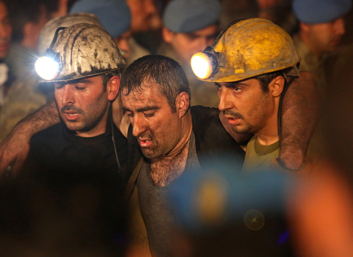 Miners are helped by rescue workers and friends from the coal mine.
