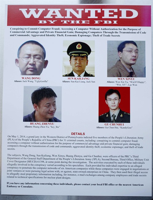 This wanted poster is displayed at the Justice Department in Washington, Monday, May 19, 2014, after the U.S. announced that a grand jury has charged five Chinese hackers with economic espionage and trade secret theft. 
