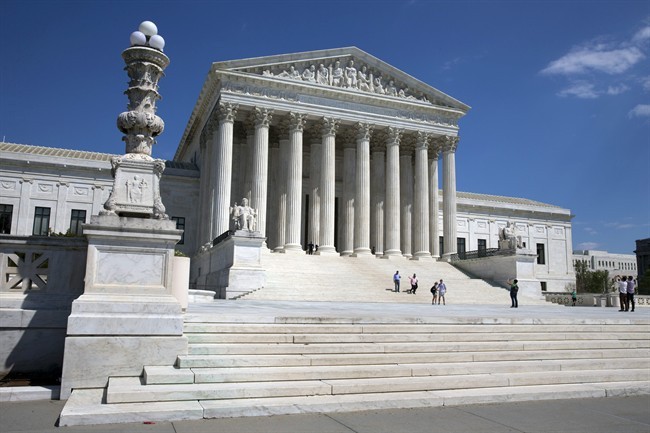 FILE - In this April 26, 2014 file photo, people walk on the steps of the U.S. Supreme Court in Washington. 