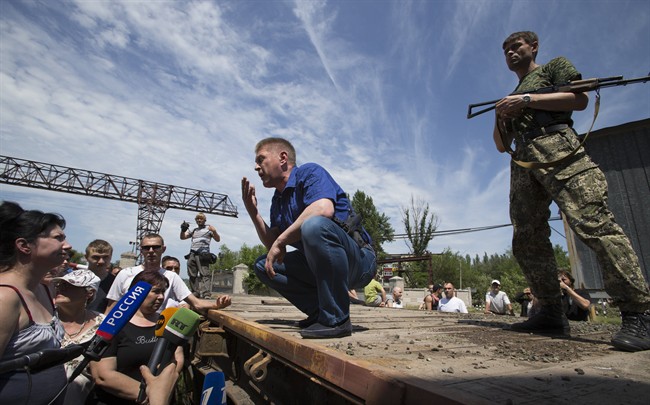 Vyacheslav Ponomarev, center, the self-proclaimed mayor of Slovyansk, speaks to local citizens whose homes were ruined in a shelling in Slovyansk, eastern Ukraine, Tuesday, May 20, 2014.