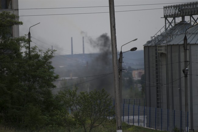 Smoke rises from a nearby explosion following a shelling from Ukrainian government forces in Slovyansk, Ukraine, Monday, May 26, 2014. 