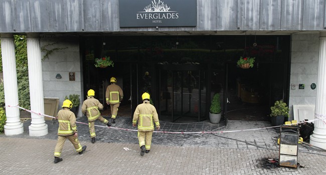 Members of the Fire Service are seen at the scene of a fire bomb at the Everglades Hotel, Londonderry, Northern Ireland, Friday, May, 30, 2014. 