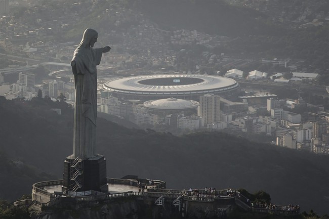 This aerial view shot through an airplane window shows the Maracana stadium behind the Christ the Redeemer statue in Rio de Janeiro, Brazil, Tuesday, May 13, 2014. As opening day for the World Cup approaches, people continue to stage protests, some about the billions of dollars spent on the World Cup at a time of social hardship, but soccer is still a unifying force. The international soccer tournament will be the first in the South American nation since 1950. (AP Photo/Felipe Dana)