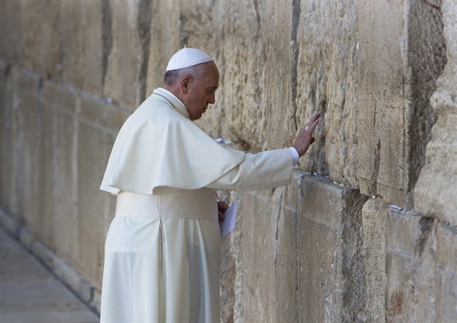 Pope Francis prays in front of the Western Wall, in Jerusalem's Old City, Monday, May 26, 2014. Pope Francis has prayed at Jerusalem's Western Wall, the holiest place where Jews can pray, bowing his head as he touched the wall in the same gesture used a day earlier to pray at the Israeli barrier surrounding the biblical West Bank town of Bethlehem. 
