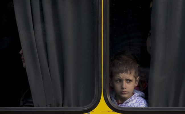 A child looks from inside a bus in Odessa, Ukraine, Tuesday, May 13, 2014.