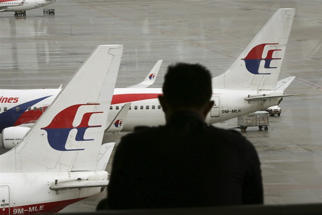 A visitor looks out from the viewing gallery as Malaysia Airlines aircraft sit on the tarmac at the Kuala Lumpur International Airport.