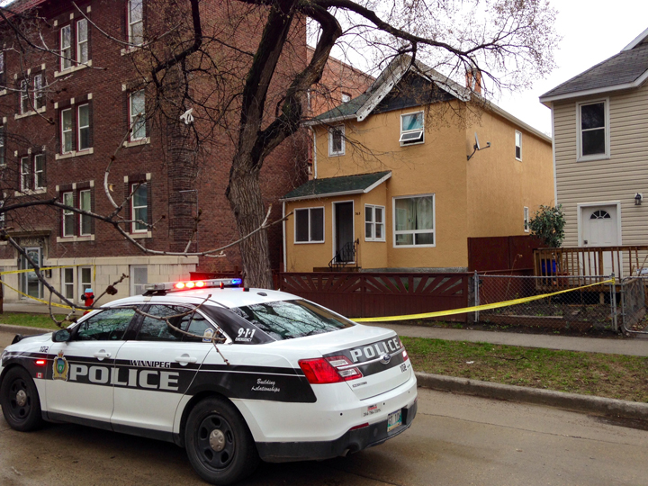 A Winnipeg police vehicle sits near the spot on Young Street where a man was found injured on Tuesday morning.