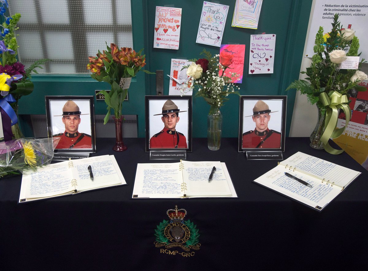 Books of condolence for Const. Fabrice Georges Gevaudan, Const. Douglas James Larche and Const. David Joseph Ross, left to right, are displayed at the Codiac RCMP detachment in Moncton, N.B. on Friday, June 6, 2014.