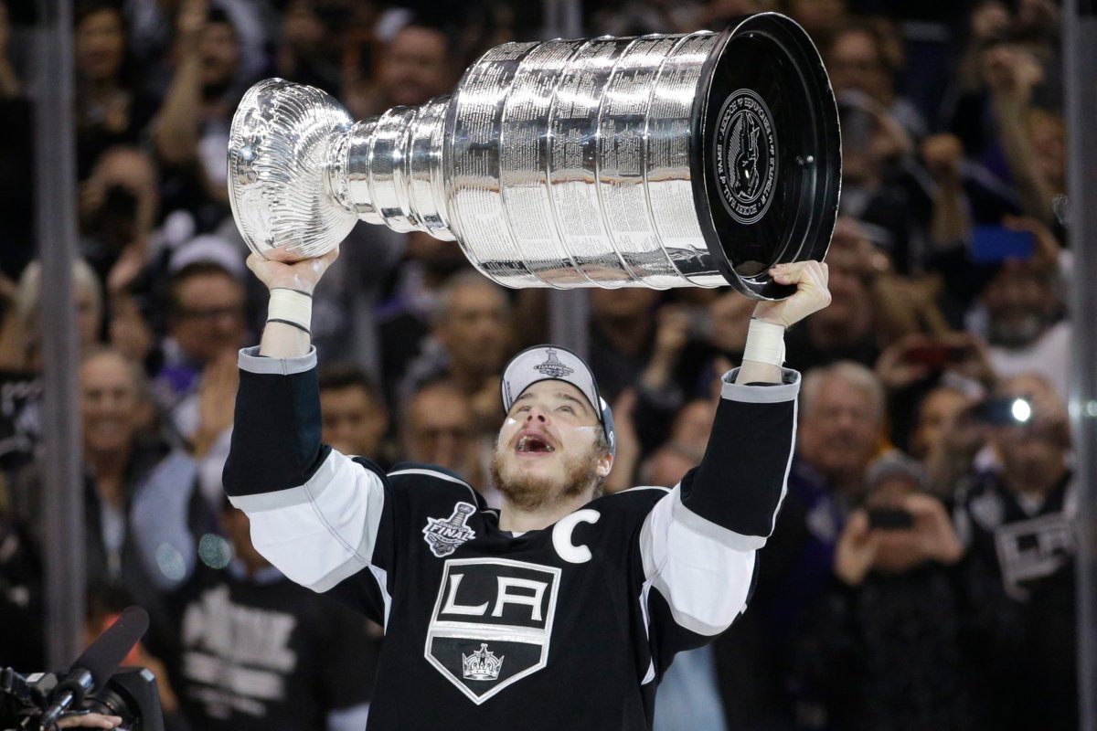 Los Angeles Kings right wing Dustin Brown raises the Stanley Cup after beating the New York Rangers in overtime in Game 5 of the NHL Stanley Cup Final series Friday, June 13, 2014, in Los Angeles. (AP Photo/Jae C. Hong).