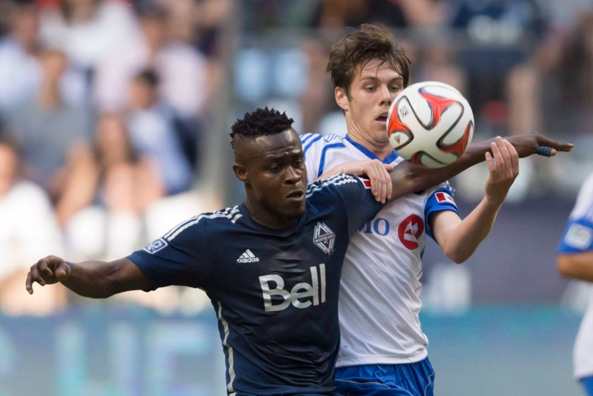 Vancouver Whitecaps' Gershon Koffie, left, and Montreal Impact's Maxim Tissot vie for the ball during first half MLS soccer action. THE CANADIAN PRESS/Darryl Dyck.