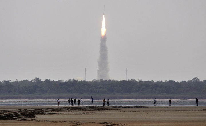 Indians watch the Polar Satellite Launch Vehicle (PSLV-C23) rocket lifting off from the east coast island of Sriharikota, India, Monday, June 30, 2014. The rocket was carrying French Earth Observation Satellite SPOT-7 with four other satellites, AISAT of Germany, NLS7.1 (CAN-X4) and NSL7.2 (CAN-X5) of Canada and VELOX-1 of Singapore. (AP Photo/Arun Sankar K.).