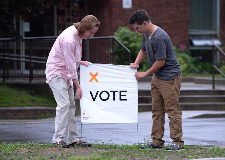Poll station workers prepare to open a poll in in Carleton Place, Ont. on Thursday June 12, 2014.